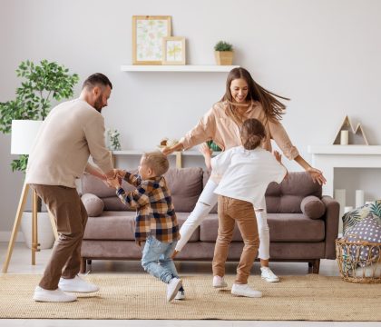 happy family mother father and kids daughter and son dancing and having fun at home